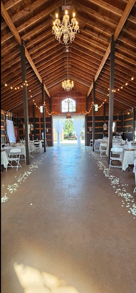 Rustic barn wedding venue with chandeliers and string lights